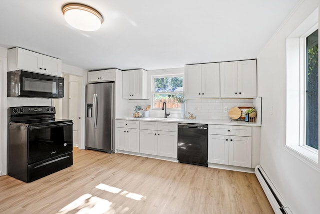 26030 2nd St W, Zimmerman, MN 55398 - kitchen with black appliances, baseboard heating, light countertops, light wood-type flooring, and decorative backsplash