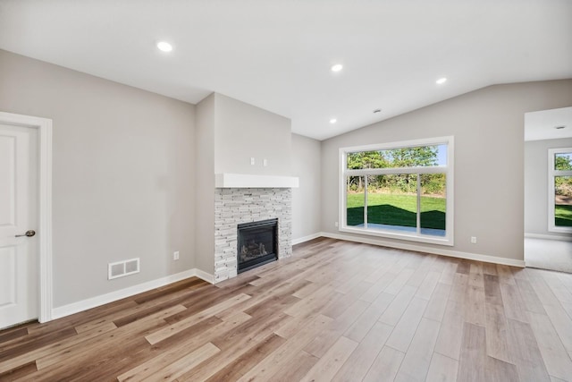 4786 384th St, North Branch, MN 55056 - unfurnished living room featuring a stone fireplace, light wood-type flooring, vaulted ceiling, and recessed lighting
