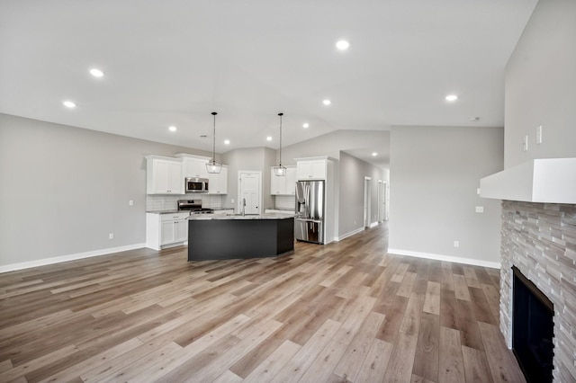 4786 384th St, North Branch, MN 55056 - kitchen with stainless steel appliances, open floor plan, lofted ceiling, white cabinets, and a fireplace