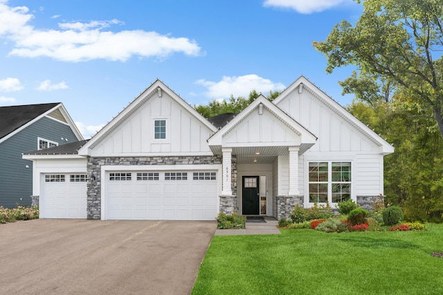6501 Tamarack Ln, Corcoran, MN 55340 - view of front of house with board and batten siding, an attached garage, stone siding, a front yard, and driveway