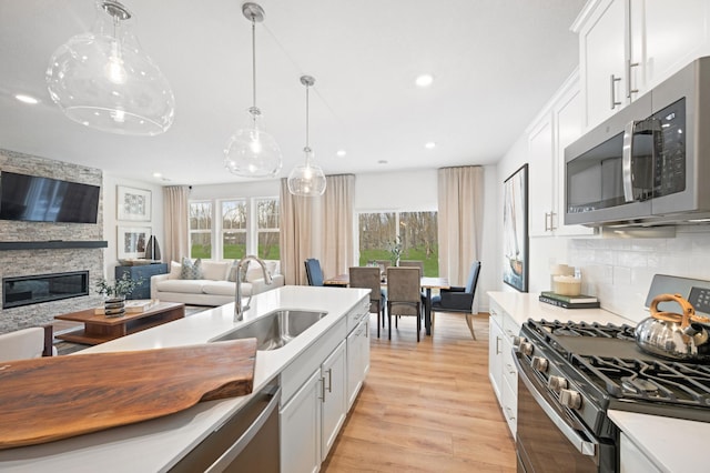 6501 Tamarack Ln, Corcoran, MN 55340 - kitchen with stainless steel appliances, recessed lighting, white cabinetry, light wood finished floors, and hanging light fixtures