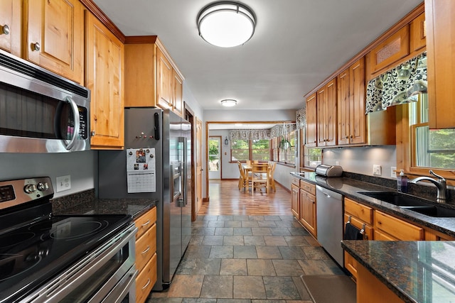 1682 Oakdale Ave W, Saint Paul, MN 55118 - kitchen featuring appliances with stainless steel finishes, stone finish flooring, dark stone countertops, and brown cabinetry