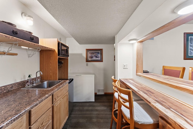 1682 Oakdale Ave W, Saint Paul, MN 55118 - kitchen with black microwave, a textured ceiling, dark wood-style flooring, dark countertops, and dishwasher