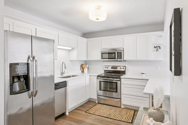 1200 Nicollet Mall Unit 523, Minneapolis, MN 55403 - kitchen with stainless steel appliances, open shelves, white cabinetry, light countertops, and a textured ceiling