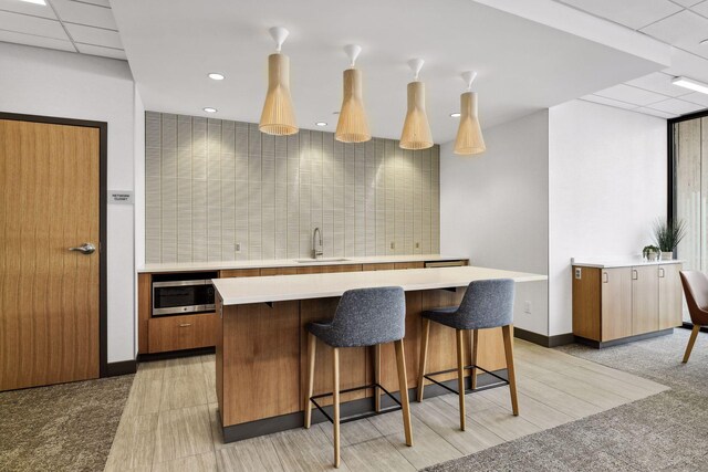 1200 Nicollet Mall Unit 523, Minneapolis, MN 55403 - kitchen featuring light countertops, a breakfast bar, a kitchen island, stainless steel microwave, and recessed lighting