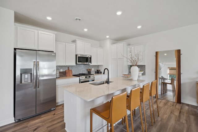 10663 Hemingway Ave S, Cottage Grove, MN 55016 - kitchen with appliances with stainless steel finishes, dark wood-type flooring, backsplash, white cabinetry, and recessed lighting