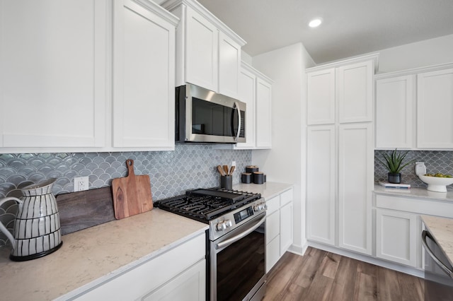 10663 Hemingway Ave S, Cottage Grove, MN 55016 - kitchen with stainless steel appliances, white cabinets, backsplash, wood finished floors, and light stone counters