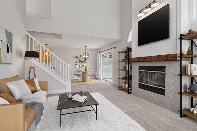 18347 Coneflower Ln, Eden Prairie, MN 55346 - living room with stairs, carpet flooring, a tiled fireplace, a chandelier, and a high ceiling