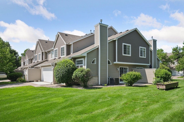 18347 Coneflower Ln, Eden Prairie, MN 55346 - view of side of property with a chimney, concrete driveway, a yard, an attached garage, and a shingled roof