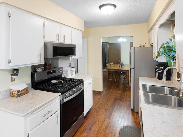 1507 234th Ln NE, Bethel, MN 55005 - kitchen with appliances with stainless steel finishes, dark wood-style floors, light countertops, white cabinets, and a textured ceiling