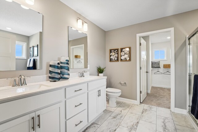 2436 Hadley Hills Dr NE, Rochester, MN 55906 - bathroom featuring double vanity, a shower with shower door, and marble finish flooring