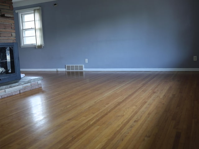 1682 Cottage Ave E, Saint Paul, MN 55106 - unfurnished living room featuring a stone fireplace and dark wood-style floors