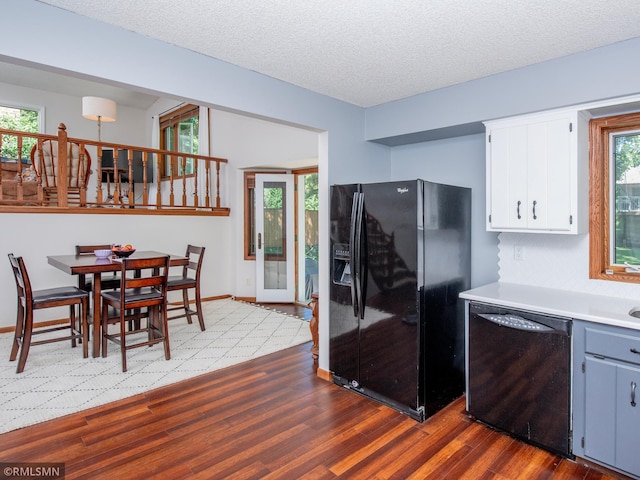 5424 Vernon Ct, Savage, MN 55378 - kitchen featuring dishwashing machine, black refrigerator with ice dispenser, dark wood-style floors, light countertops, and white cabinetry