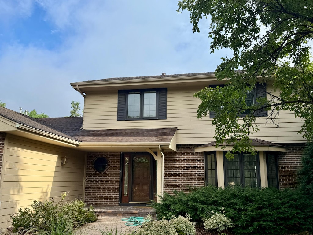 12280 48th Ave N, Plymouth, MN 55442 - view of exterior entry featuring brick siding and roof with shingles