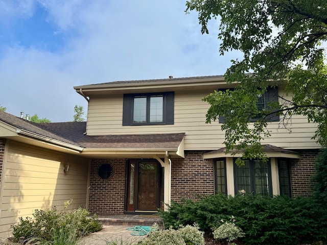12280 48th Ave N, Plymouth, MN 55442 - view of exterior entry featuring brick siding and roof with shingles
