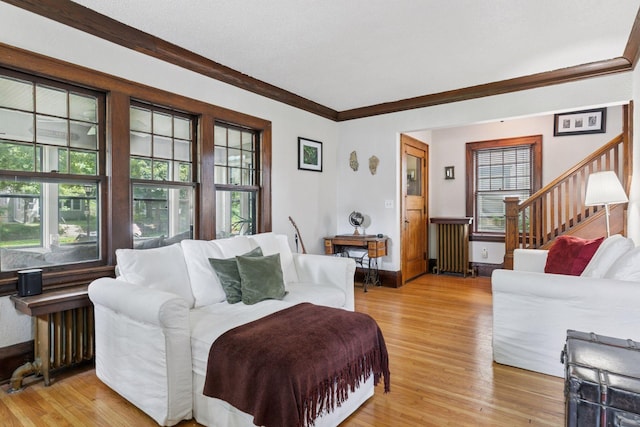 1756 Minnehaha Ave W, Saint Paul, MN 55104 - living area with radiator heating unit, light wood-type flooring, ornamental molding, and stairs