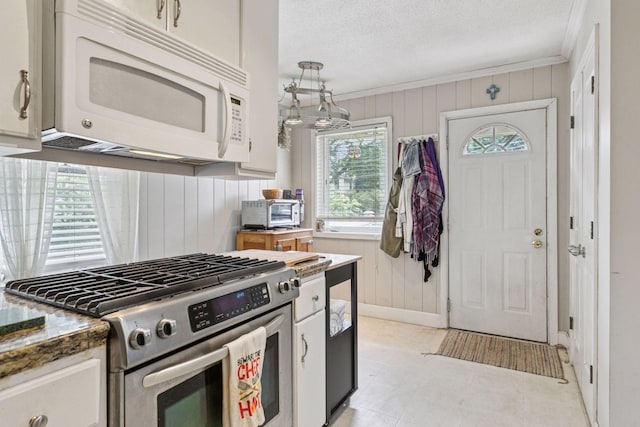 1756 Minnehaha Ave W, Saint Paul, MN 55104 - kitchen with stainless steel gas range, white microwave, wooden walls, ornamental molding, and a textured ceiling