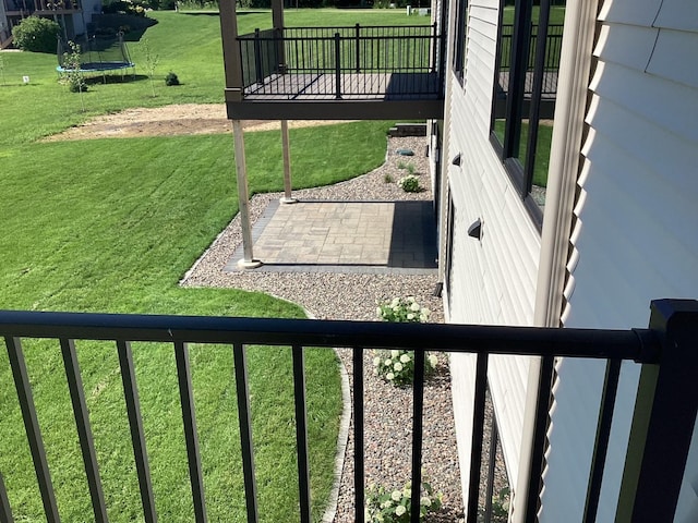 2334 9th St W, Albert Lea, MN 56007 - view of green lawn with a trampoline, a patio, and a wooden deck