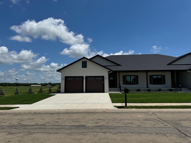 2334 9th St W, Albert Lea, MN 56007 - view of front facade with concrete driveway, a front lawn, a garage, and a shingled roof