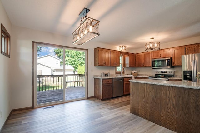 5445 Large Ave NE, Albertville, MN 55301 - kitchen featuring appliances with stainless steel finishes, a chandelier, light wood-type flooring, and plenty of natural light