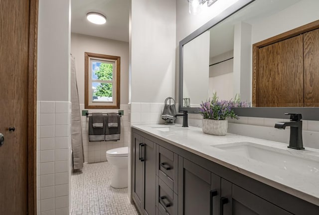 5445 Large Ave NE, Albertville, MN 55301 - bathroom featuring double vanity, tile patterned flooring, wainscoting, and tile walls