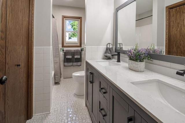 5445 Large Ave NE, Albertville, MN 55301 - bathroom with double vanity, tile walls, tile patterned floors, a shower with curtain, and wainscoting