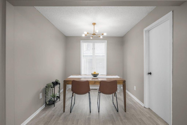 402 Clifton St, Saint Paul, MN 55102 - dining room with a chandelier, light wood-type flooring, and a textured ceiling