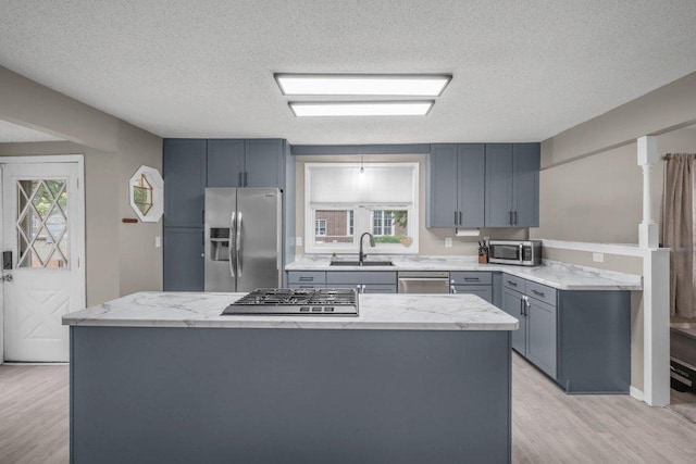 402 Clifton St, Saint Paul, MN 55102 - kitchen featuring stainless steel appliances, light wood-type flooring, healthy amount of natural light, a textured ceiling, and gray cabinets