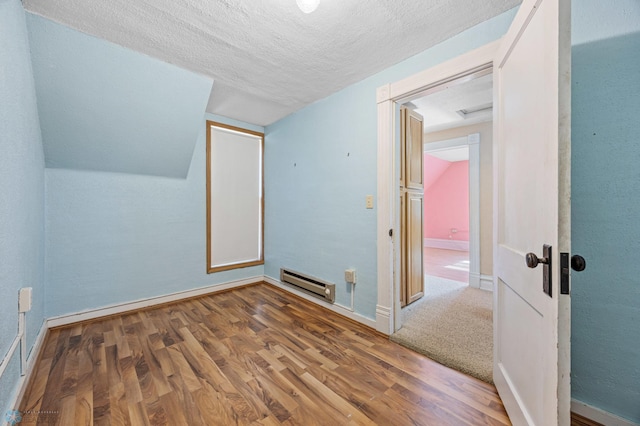 362 5th Ave N, Casselton, ND 58012 - bonus room featuring baseboard heating, wood finished floors, a textured ceiling, and lofted ceiling