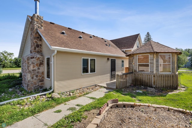 362 5th Ave N, Casselton, ND 58012 - rear view of house featuring a wooden deck, a shingled roof, and a chimney