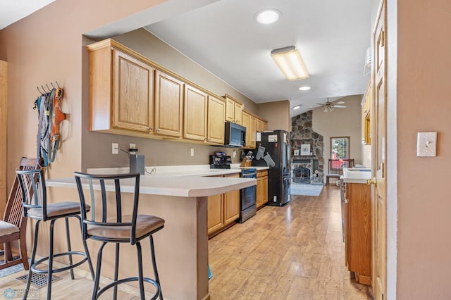 362 5th Ave N, Casselton, ND 58012 - kitchen featuring electric range, freestanding refrigerator, black microwave, a peninsula, and light wood finished floors