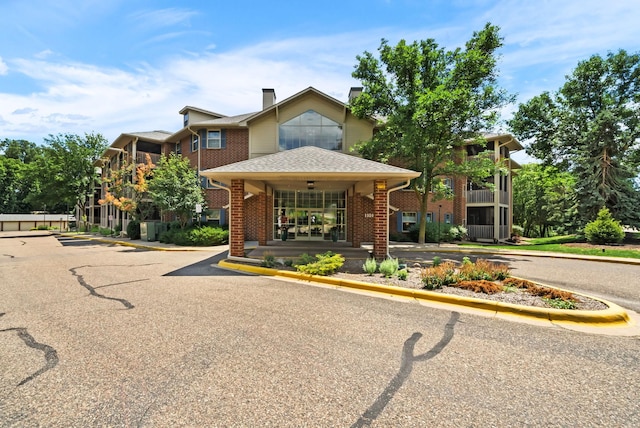 1350 Douglas Dr N Unit 105, Golden Valley, MN 55422 - view of front of home with a chimney, brick siding, and a shingled roof