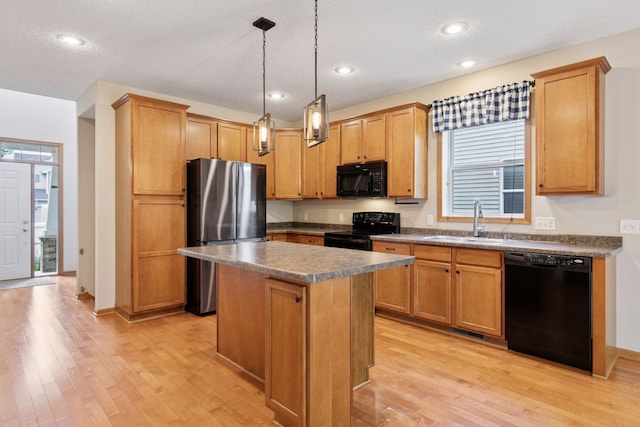 1767 Switchgrass Ct, Shakopee, MN 55379 - kitchen with black appliances, light wood-style flooring, a center island, hanging light fixtures, and dark countertops