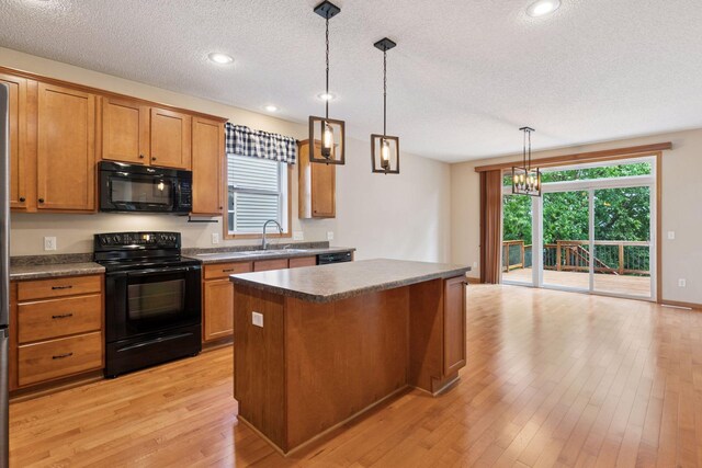 1767 Switchgrass Ct, Shakopee, MN 55379 - kitchen featuring black appliances, a kitchen island, a textured ceiling, light wood-type flooring, and brown cabinetry
