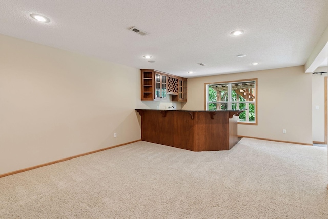 1767 Switchgrass Ct, Shakopee, MN 55379 - kitchen featuring open shelves, a peninsula, carpet flooring, glass insert cabinets, and a breakfast bar