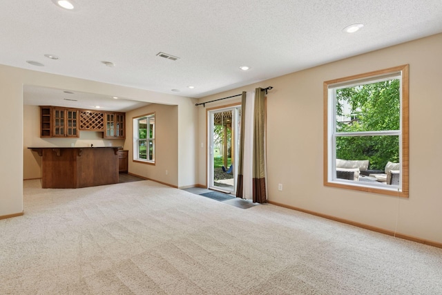 1767 Switchgrass Ct, Shakopee, MN 55379 - unfurnished living room featuring carpet, plenty of natural light, bar with sink, and recessed lighting