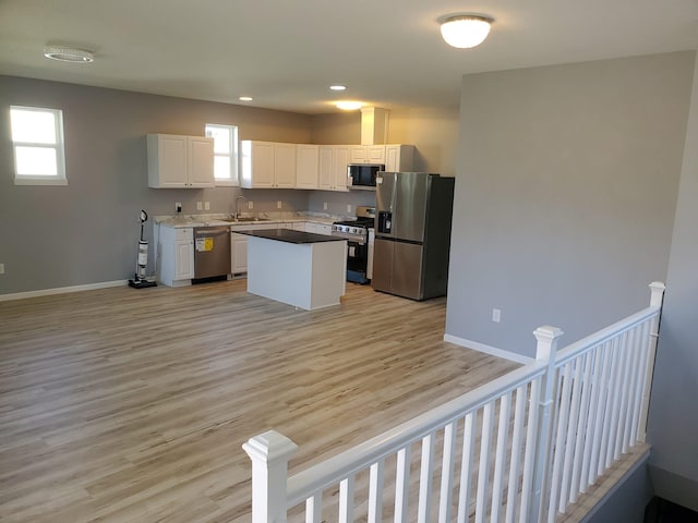 1884 Ames Ave, Saint Paul, MN 55119 - kitchen featuring stainless steel appliances, white cabinetry, light wood-style floors, a kitchen island, and recessed lighting