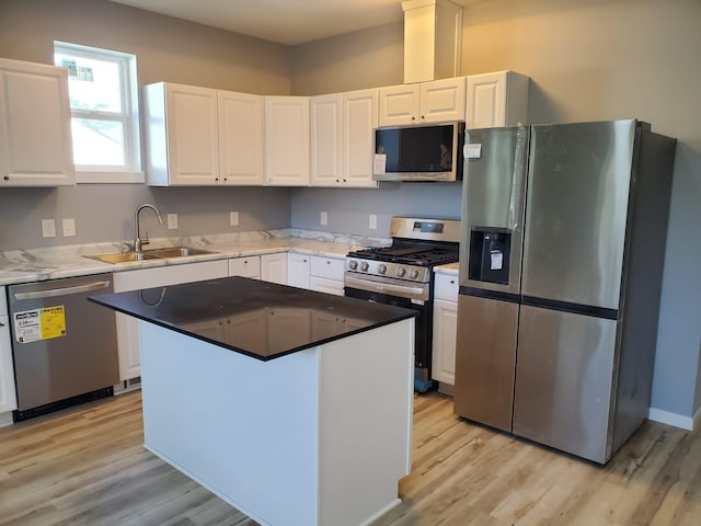 1884 Ames Ave, Saint Paul, MN 55119 - kitchen with appliances with stainless steel finishes, white cabinetry, light wood-style floors, and a kitchen island