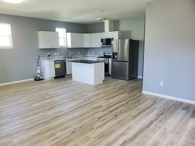 1884 Ames Ave, Saint Paul, MN 55119 - kitchen with appliances with stainless steel finishes, white cabinetry, light wood-style floors, and a center island