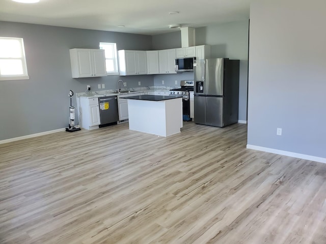 1884 Ames Ave, Saint Paul, MN 55119 - kitchen with stainless steel appliances, white cabinetry, light wood-type flooring, and a kitchen island