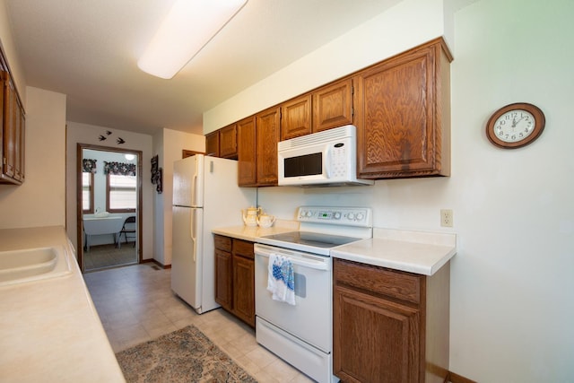 608 Pfau St, Mankato, MN 56001 - kitchen with white appliances, light countertops, and brown cabinetry