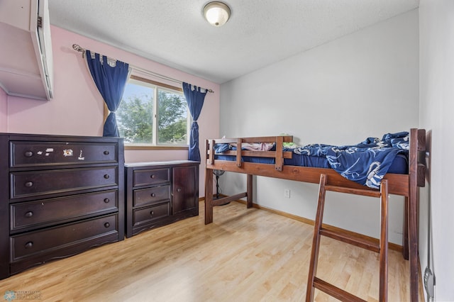 901 7th St W, West Fargo, ND 58078 - bedroom featuring light wood-style floors, a textured ceiling, and an office area