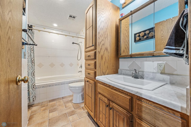 901 7th St W, West Fargo, ND 58078 - bathroom with vanity, tiled shower / bath combo, and a textured ceiling