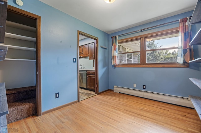 3113 8th St N, Fargo, ND 58102 - unfurnished bedroom with baseboard heating, light wood-type flooring, and ensuite bathroom