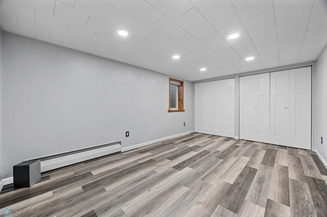 3113 8th St N, Fargo, ND 58102 - unfurnished bedroom featuring wood finished floors, baseboard heating, two closets, and recessed lighting