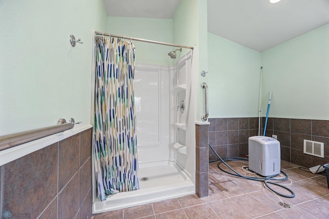 3113 8th St N, Fargo, ND 58102 - bathroom with a shower stall, tile walls, tile patterned floors, and wainscoting