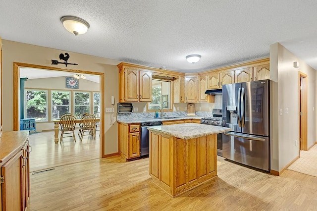 417 Whiskey Rd SW, Isanti, MN 55040 - kitchen with appliances with stainless steel finishes, light wood-style floors, light countertops, under cabinet range hood, and a center island