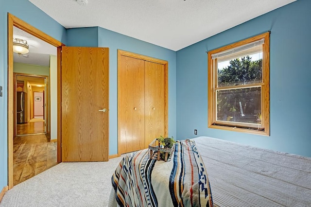 417 Whiskey Rd SW, Isanti, MN 55040 - carpeted bedroom with freestanding refrigerator, a closet, and a textured ceiling