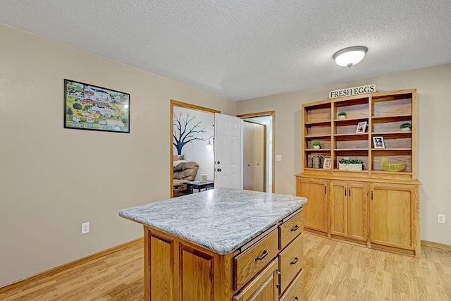 417 Whiskey Rd SW, Isanti, MN 55040 - kitchen featuring light wood-style floors, a textured ceiling, a kitchen island, light stone countertops, and open shelves
