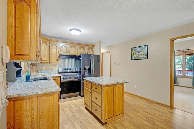 417 Whiskey Rd SW, Isanti, MN 55040 - kitchen with appliances with stainless steel finishes, light wood-type flooring, a kitchen island, under cabinet range hood, and a textured ceiling